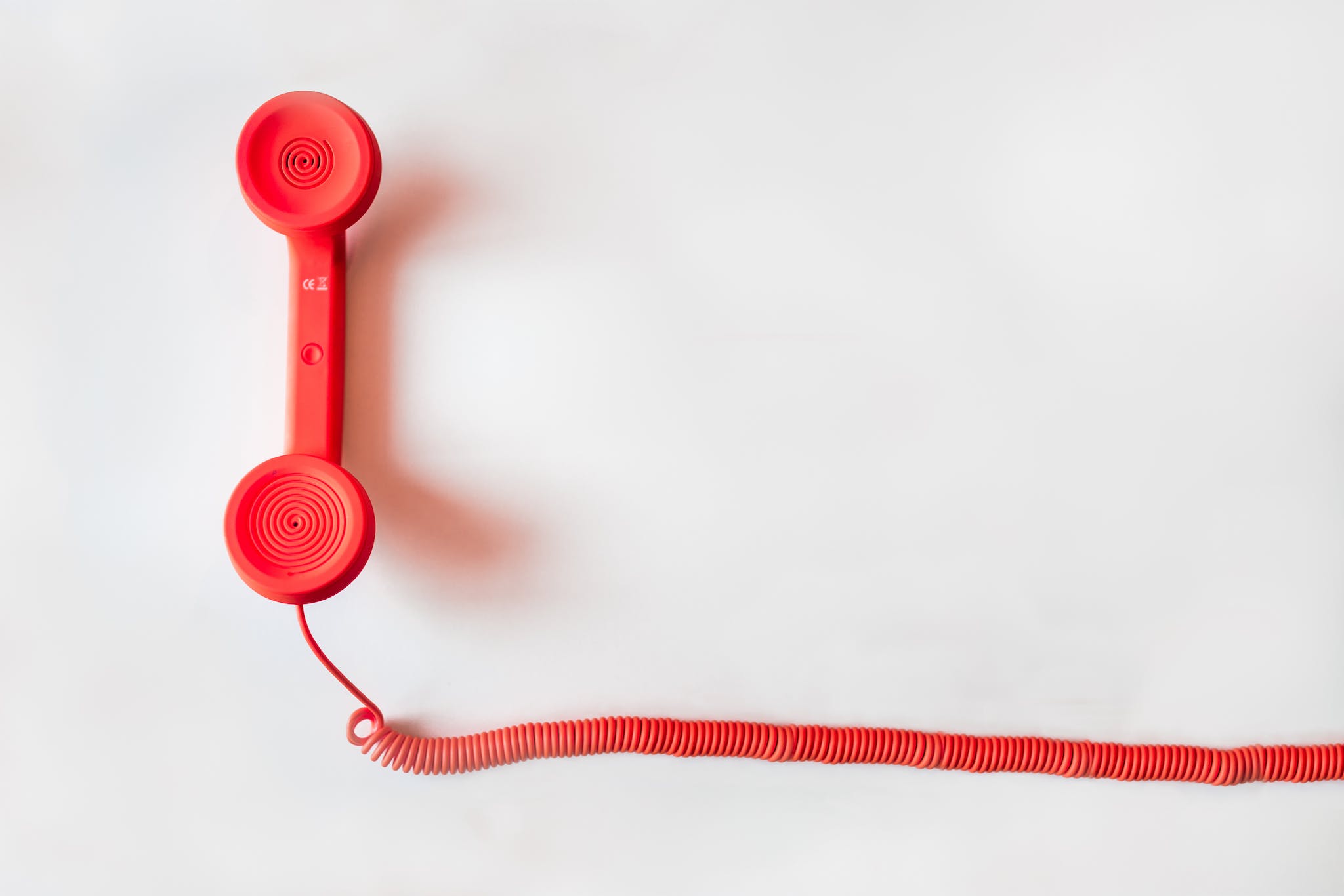 Telephone rouge à cordon sur une surface blanche